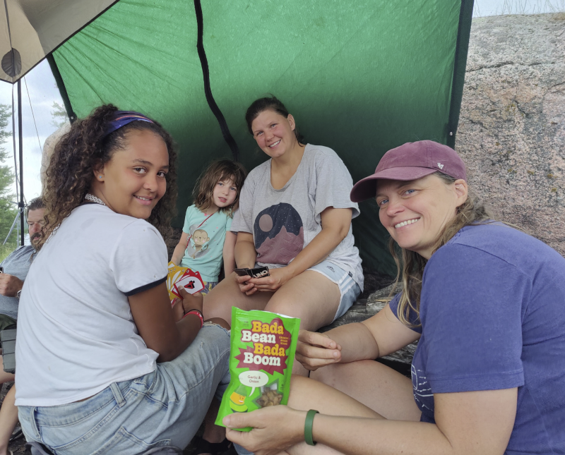 Waiting Out the Rain With a Card Game and Snacks While Camping With Friends